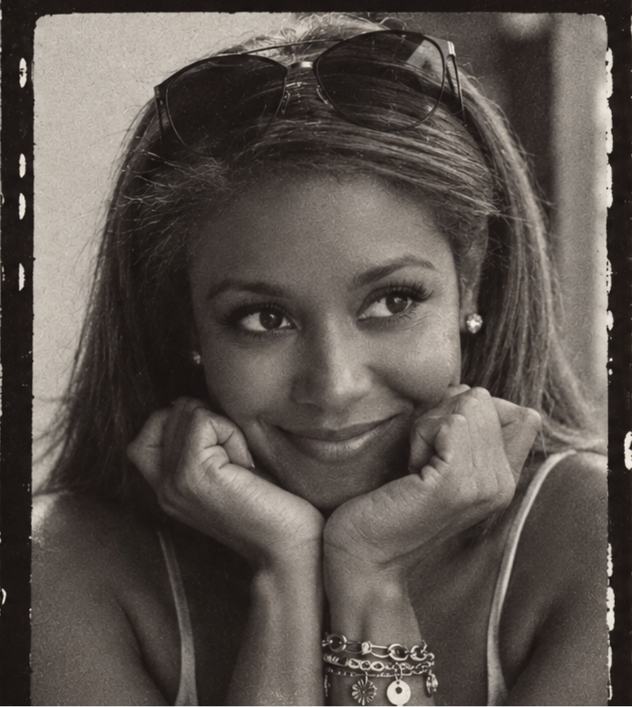A black and white close-up portrait of Jasmine Jones resting her chin on her hands, framed in a vintage film-strip border style with a top crop panel showing the lower half of her face.