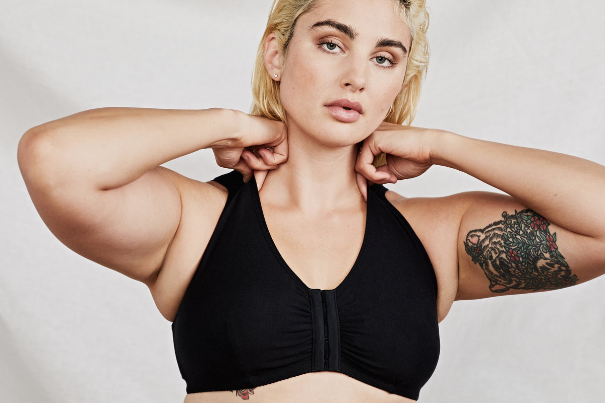 Woman wearing a black sports bra with a neutral background